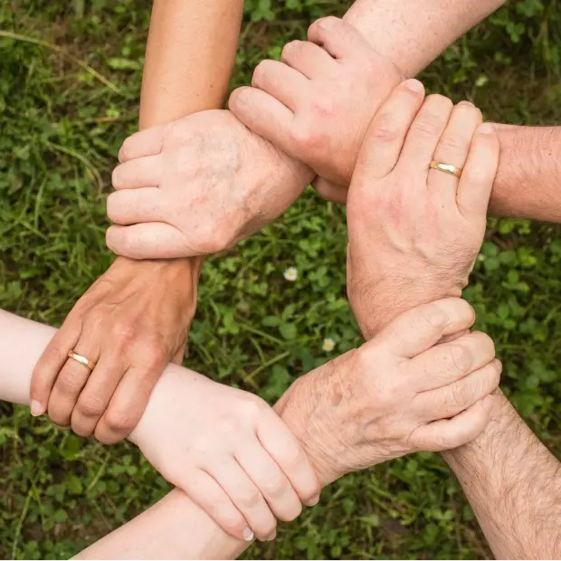 Fotografia de varias mão, uma segurando a outra pelo punho