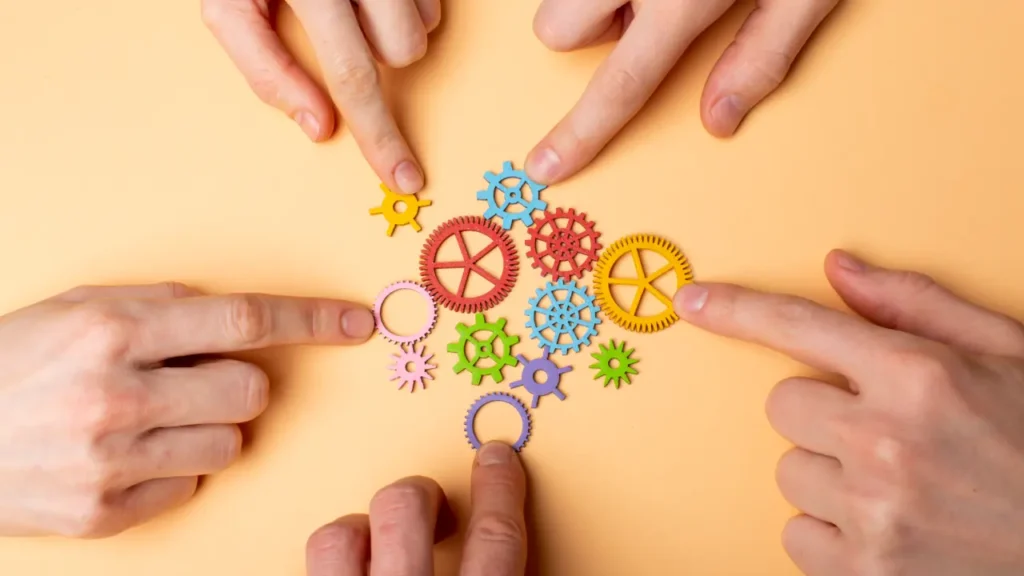Imagem de varias mãos apontando para varias engrenagens