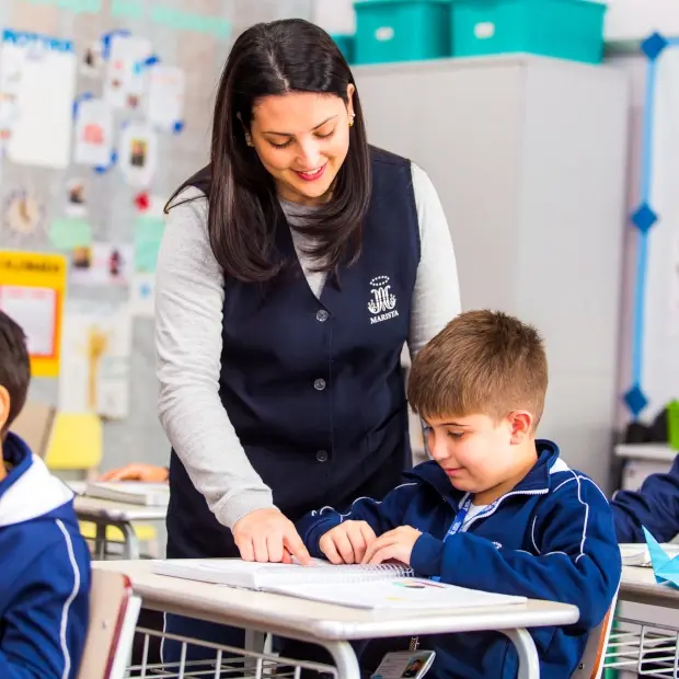 Fotografia de uma professora ensinando uma criança.